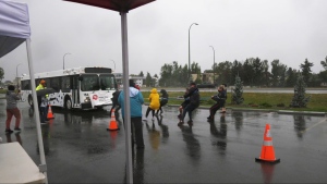 Volunteers brave cold and rain to pull the bus in fundraiser for United Way of Lethbridge